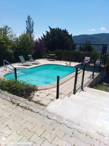 une piscine avec des chaises et une clôture dans l'établissement Studio confortable à Veyras avec jardin et piscine, à Veyras