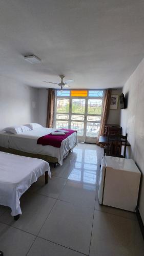 a bedroom with two beds and a large window at HOTEL ESTAÇÃO in Diamantina
