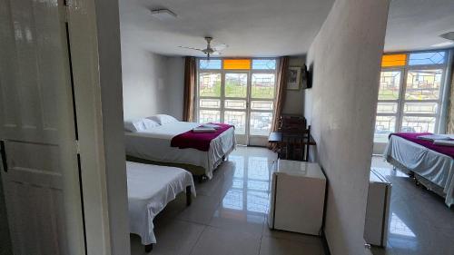 a room with two beds and a window at HOTEL ESTAÇÃO in Diamantina