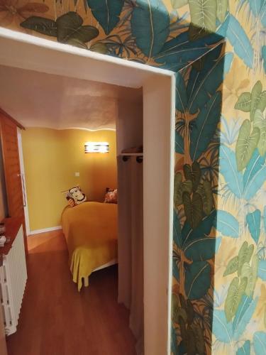 - une chambre avec un lit et une fresque murale représentant des feuilles dans l'établissement Studio Athena, à Aix-les-Bains