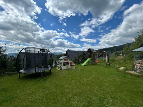 einen Hof mit einer Schaukel und einem Spielplatz in der Unterkunft Apartmány Aram Kubínska hoľa in Dolný Kubín