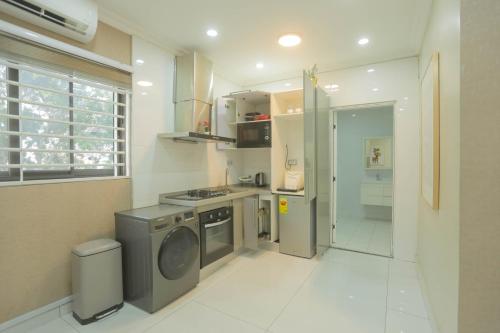 a kitchen with a washing machine and a refrigerator at Accra Luxury Apartments @ Silicon Square in Accra