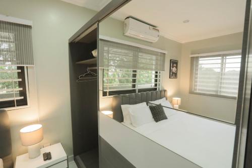 a bedroom with a bed with a large mirror at Accra Luxury Apartments @ Silicon Square in Accra