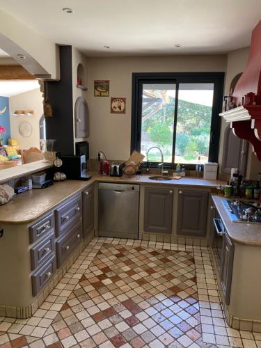 une cuisine avec un évier et une fenêtre dans l'établissement Le Mas du Garlaban, à Aubagne