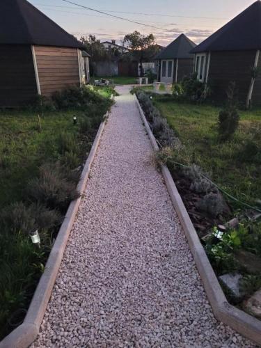 a gravel path in a yard next to a house at The Vie Llage - Authorial Suites Bungalows in Vagos