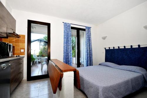 Cet appartement comprend une chambre avec un lit et une cuisine avec un balcon. dans l'établissement Casa L'Ascosu, à Esigna