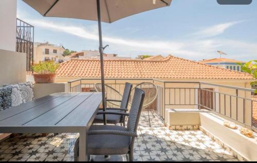 a table and chairs on a balcony with an umbrella at Maisonette Pylos in Pylos