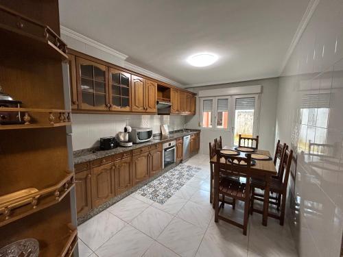 a kitchen with wooden cabinets and a table and chairs at A de Javi in Boiro
