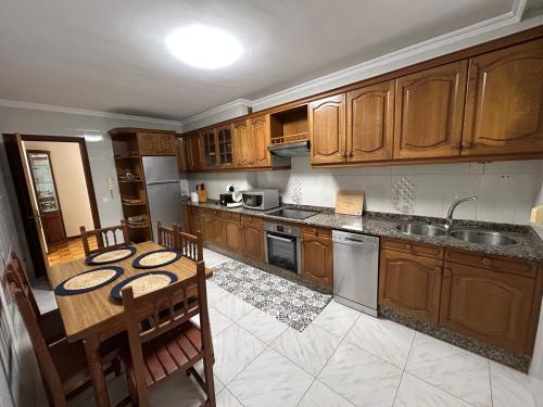 a kitchen with wooden cabinets and a table with chairs at A de Javi in Boiro