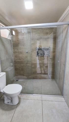 a bathroom with a toilet and a glass shower at HOTEL ESTAÇÃO in Diamantina