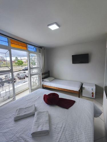 a bedroom with a large bed and a large window at HOTEL ESTAÇÃO in Diamantina