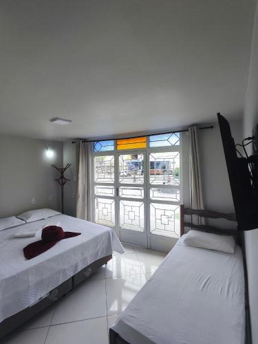 a bedroom with two beds and a large window at HOTEL ESTAÇÃO in Diamantina