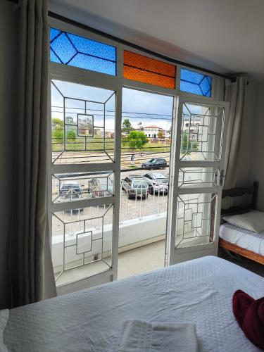 a bedroom with a large window with a view of a parking lot at HOTEL ESTAÇÃO in Diamantina