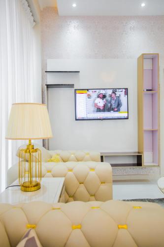 a living room with a couch and a tv at Accra Luxury Apartments @ Silicon Square in Accra