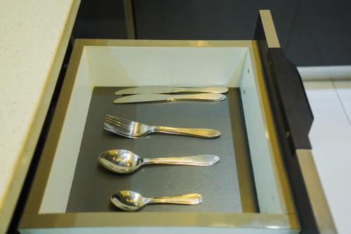 a wooden box with gold forks and spoons at Accra Luxury Apartments @ Silicon Square in Accra