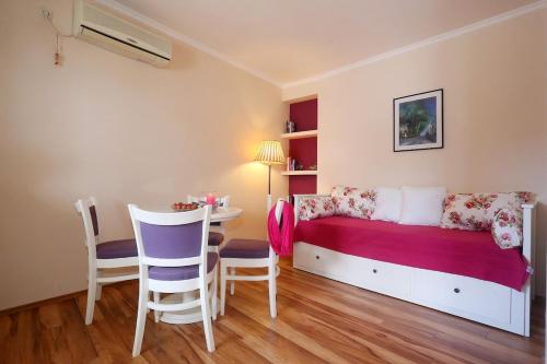 une chambre avec un lit, une table et des chaises dans l'établissement Luxury Sunny Apartment, à Mlini