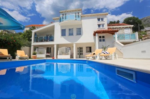 une villa avec piscine devant une maison dans l'établissement Luxury Sunny Apartment, à Mlini