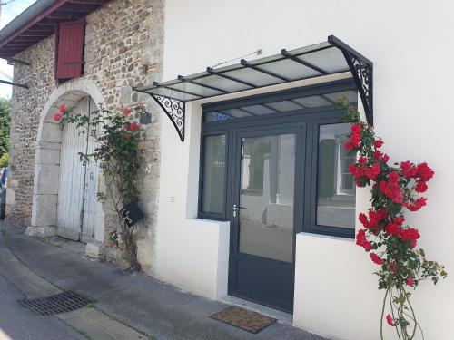 a black door with flowers on the side of a building at La maison de Sophie in Carresse