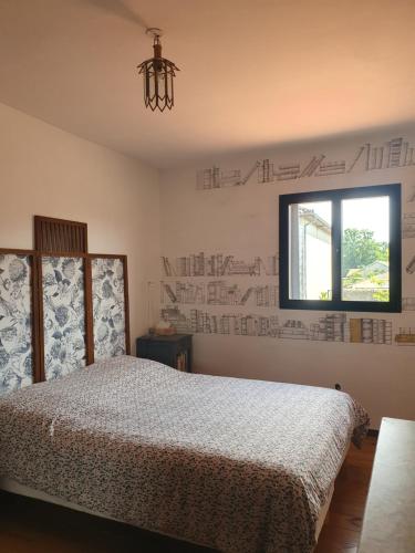 - une chambre avec un lit et une fenêtre avec un bureau sur le mur dans l'établissement La maison de Sophie, à Carresse