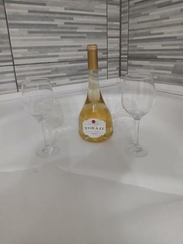 a bottle of wine sitting between two wine glasses at MilicaNS2 in Novi Sad