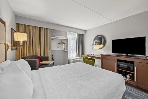 a hotel room with a bed and a flat screen tv at Hampton Inn Toledo-South/Maumee in Maumee