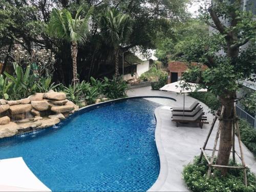 a swimming pool with a bench and an umbrella at B8 Ватсап669З5В2I976 in Nai Yang Beach