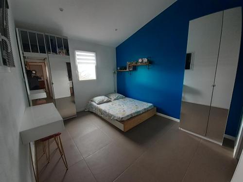 une chambre avec un mur bleu et un lit dans l'établissement vacances en Luberon, à Viens