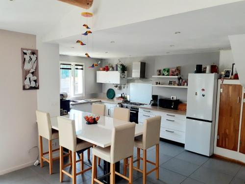 une cuisine avec une table et des chaises et un réfrigérateur blanc dans l'établissement vacances en Luberon, à Viens