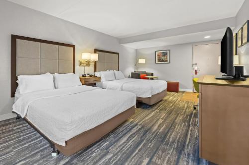 a hotel room with two beds and a flat screen tv at Hampton Inn Toledo-South/Maumee in Maumee