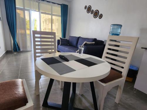 a table and chairs in a living room with a couch at Cozy 1 bedroom Coastal Condo Beachside Bliss Near Golf & Adventure in Malindi