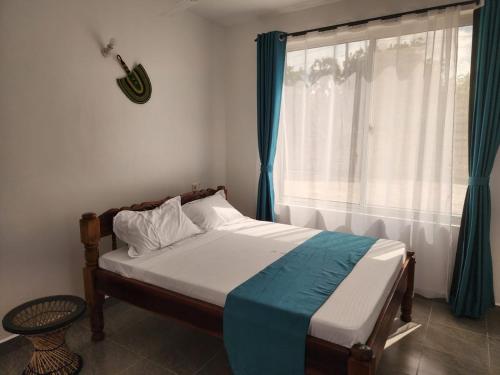 a bedroom with a bed and a window with a guitar at Cozy 1 bedroom Coastal Condo Beachside Bliss Near Golf & Adventure in Malindi