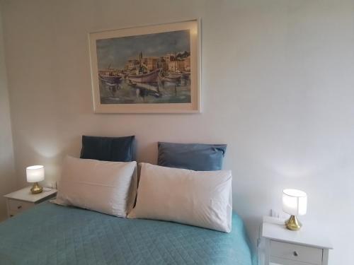 a bedroom with a bed with a painting on the wall at ANITA B&B in Uscio