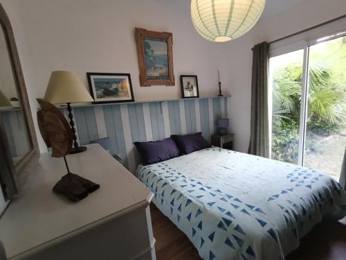 une chambre avec un lit et une fenêtre dans l'établissement Charmante maison au calme proche des commodités, à Meschers-sur-Gironde