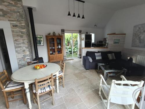 un salon avec une table, des chaises et un canapé dans l'établissement Charmante maison au calme proche des commodités, à Meschers-sur-Gironde