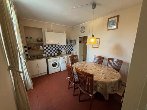 une cuisine avec une table et des chaises ainsi qu'une cuisine avec une table et une table dans l'établissement Villa Sainte-Odile, à Saint-Honoré-les-Bains