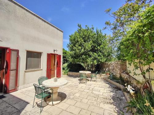 a patio with a table and chairs in a yard at La Specchia - Dimore in natura in Cisternino