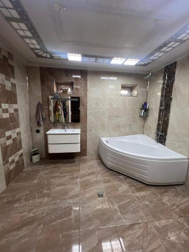 a bathroom with a large tub and a sink at La villa de Ramil in Baku