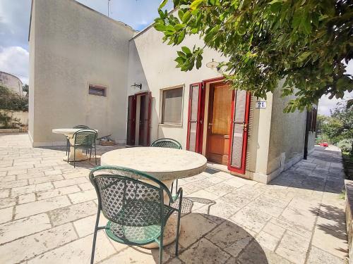 a patio with a table and chairs in front of a building at La Specchia - Dimore in natura in Cisternino