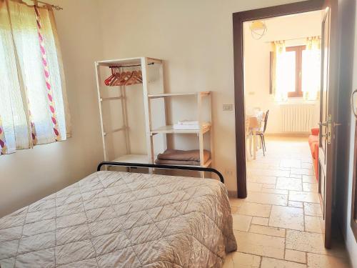 a bedroom with a bed and a room with a window at La Specchia - Dimore in natura in Cisternino