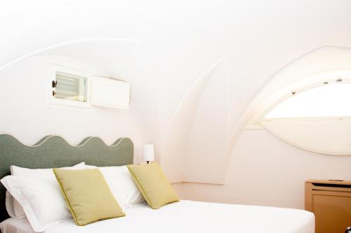 sypialnia z białym łóżkiem i łukiem w obiekcie Masseria Don Luigi-Luxury Farmhouse w mieście Savelletri di Fasano