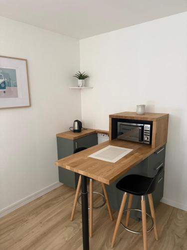 - une cuisine avec un bureau, un four micro-ondes et un tabouret dans l'établissement Le Bastion I, au Havre