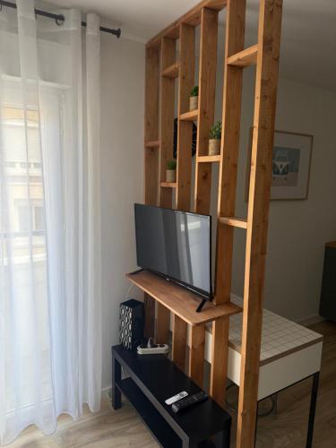 - un salon avec une télévision et une étagère dans l'établissement Le Bastion I, au Havre