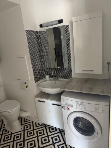 une salle de bain avec une machine à laver et un lavabo dans l'établissement Le Bastion I, au Havre