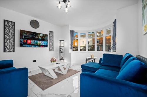 a living room with two blue couches and a table at NEC BHX Free Parking Luxury Prestige Cosy Elegance in Birmingham