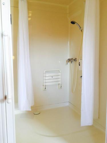a bathroom with a shower with a shower curtain at Premiere Classe Nevers Varennes Vauzelles in Varennes Vauzelles