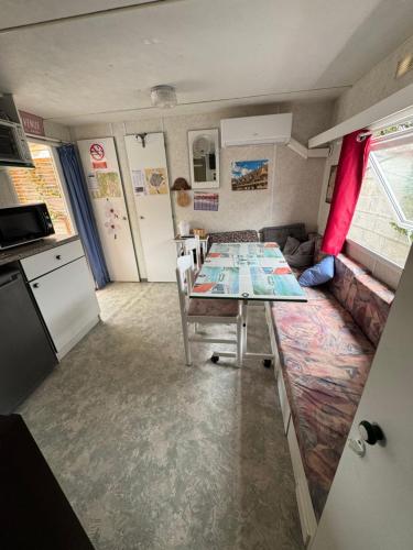 une cuisine et un salon avec une table et un canapé dans l'établissement Mobilhome situé côté ville et côté campagne, à Beaune