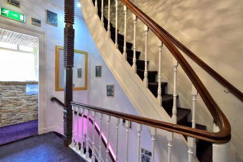 una escalera en una casa con barandilla de madera en Hotel La Belle Vue, en Ámsterdam