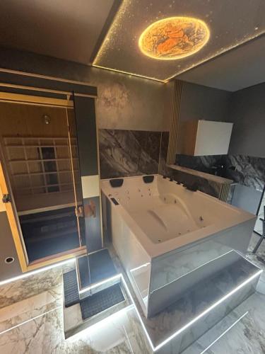 エッセンにあるWellness Suite Essen mit Whirlpool & Saunaの広いバスルーム(バスタブ、鏡付)