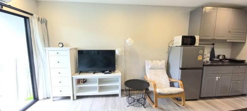 a living room with a tv and a chair and a refrigerator at B8 Ватсап669З5В2I976 in Nai Yang Beach