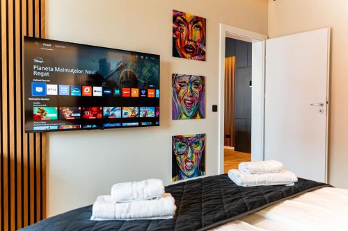 a bedroom with a bed with a flat screen tv on the wall at Central Paul Deluxe Apartment - by Open House in Timişoara